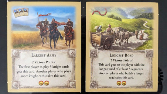 How to play Catan - photo of the largest army card and the longest road card from Settlers of Catan