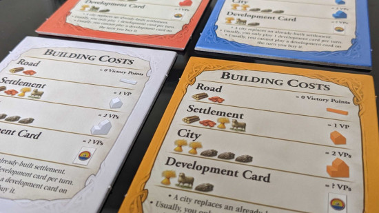 How to play Catan - photo of building cost reference cards from Settlers of Catan