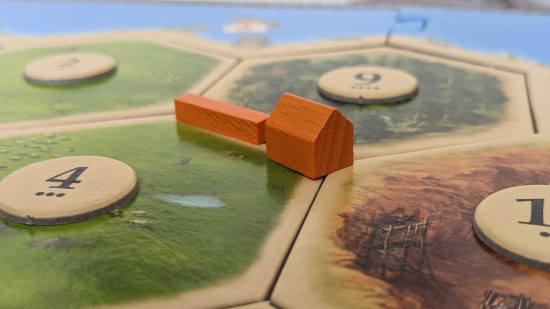 How to play Catan rules - photo of a settlement and a road in Settlers of Catan