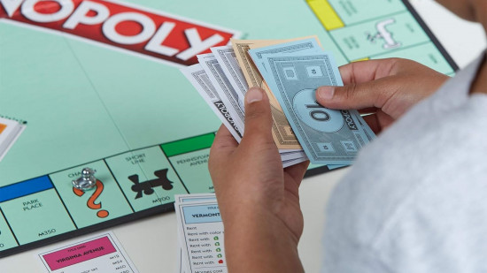 Monopoly rules - A child holding Monopoly money