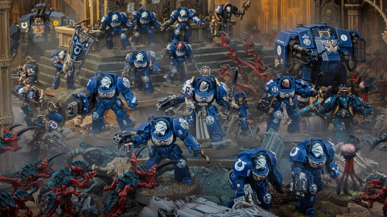 Warhammer 40k Space Marine terminators - a group of warriors in heavy blue armor with white helmets advance through rubble in the face of alien opposition