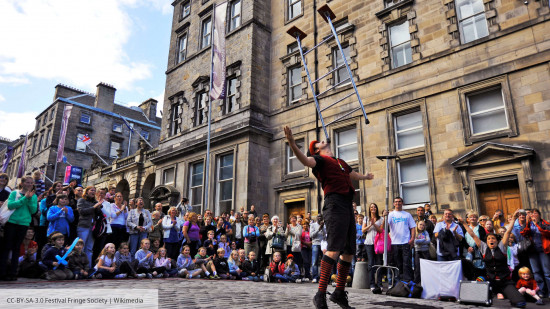 As treet performer balances a ladder on their chin during the Edinburgh Fringe - photograph CCBYSA-3.0 Festival Fringe Society