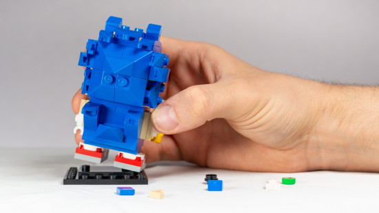 Lego Sonic the Hedgehog Brickheadz review image showing the set from behind with a giant human hand clasping it.