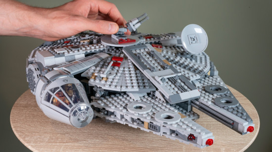 Lego Star Wars: Millennium Falcon review image showing the assembled set on a table with someone touching it.