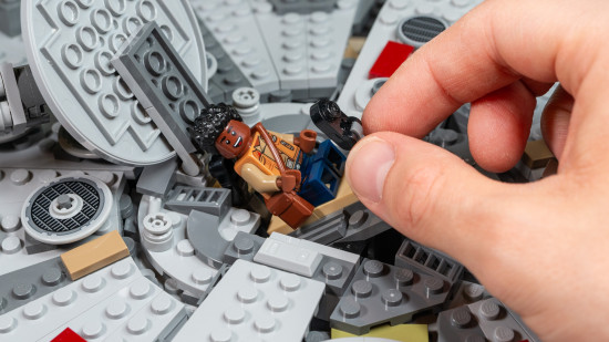 Lego Star Wars: Millennium Falcon review image showing a person adjusting Finn in a chair.