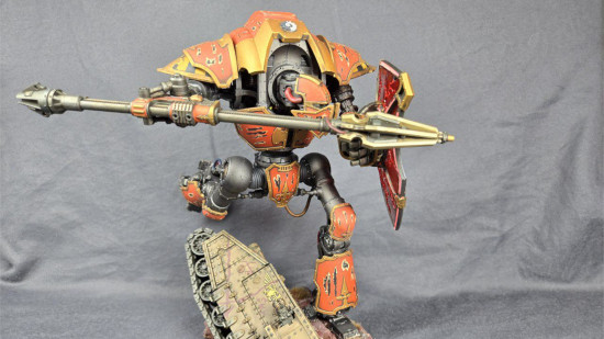 A Warhammer 40k Cerastus Knight Lancer model posed leaping over a ruined baneblade tank chassis