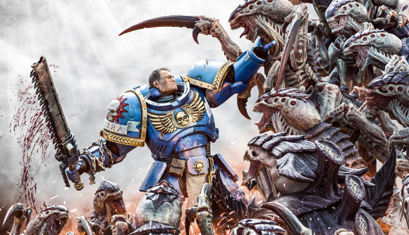 Key art from Warhammer 40k Space Marine 2 - the blue armored Space Marine Lt. Titus holds back a tide of ravenous Tyranid aliens, representing the game devs battling leaks