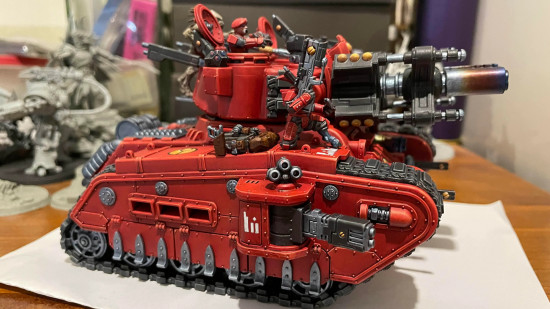 A bright red Warhammer 40k Rogal Dorn battle tank converted to be part of the T'au Empire with hammerhead ion cannon main gun